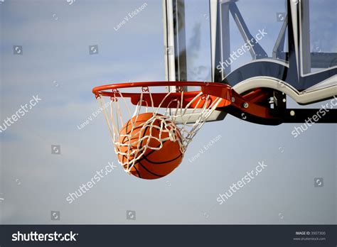 Action Shot Of Basketball Going Through Basketball Hoop And Net Stock