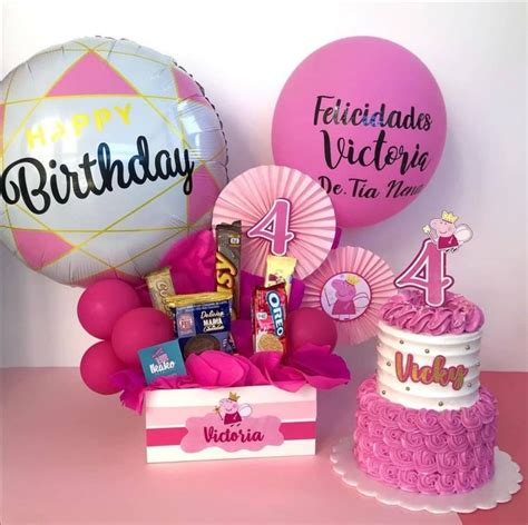 A Pink Birthday Cake And Balloons On A Table With A Box Of Chocolates