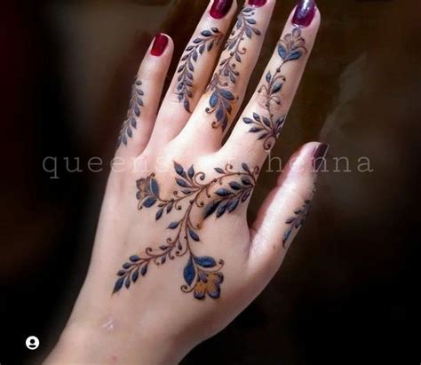 A Woman S Hand With Tattoos On It And Her Nails Painted In Blue Flowers