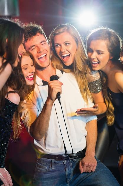 Premium Photo Happy Friends Singing Karaoke Together