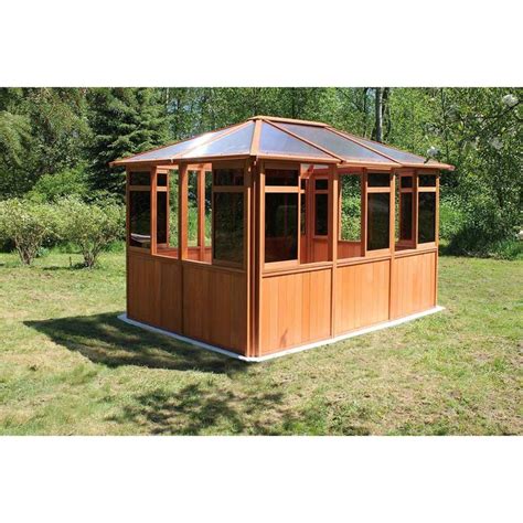 A Wooden Gazebo Sitting On Top Of A Lush Green Field In Front Of Trees