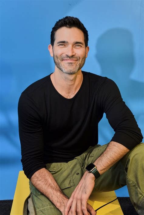 A Man Sitting On Top Of A Yellow Bench Next To A Blue And White Wall