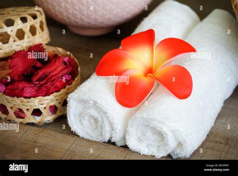 White Towels Decorate With Orange Flower Near Dry Aroma Rose On Spa Set