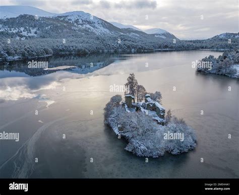 Aerial View Of Ruined Castle In Snow On Loch An Eilein In Cairngorms