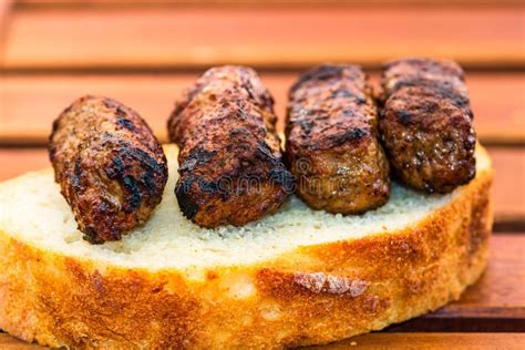 Meat Rolls Called Mici Or Mititei On A Slice Of Bread Isolated Stock