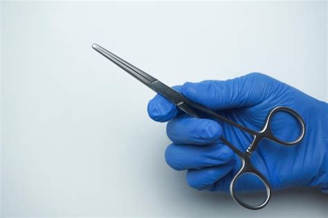 Premium Photo Doctor Wearing Blue Medical Gloves Holding Allis