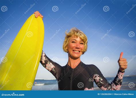 Young Beautiful And Happy Surfer Woman Holding Yellow Surf Board