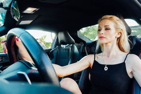 Beautiful Blonde Woman Behind The Wheel Of Car Rides Stock Image