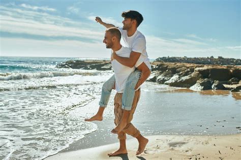 Lovely Gay Couple On Piggyback Ride At The Beach Stock Photo Image Of Landscape Piggyback