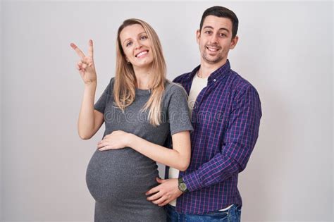 Pareja Joven Que Espera Un Beb De Pie Sobre Fondo Blanco Sonriendo Con