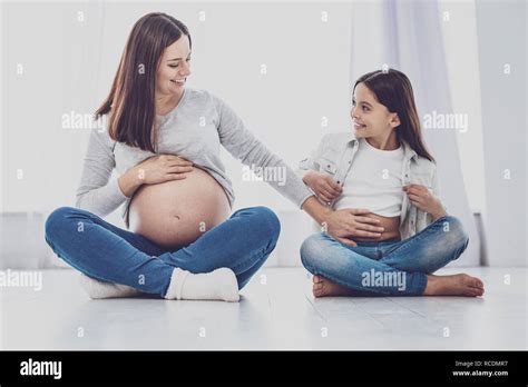 Cheerful Pregnant Woman Touching Belly Of Her Daughter Stock Photo Alamy