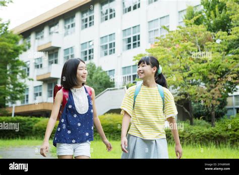Two Primary School Girls Conversing With A Smile Stock Photo Alamy