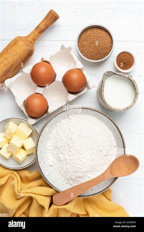 Ingredients for baking on white wooden table. Wheat flour, eggs, milk ...