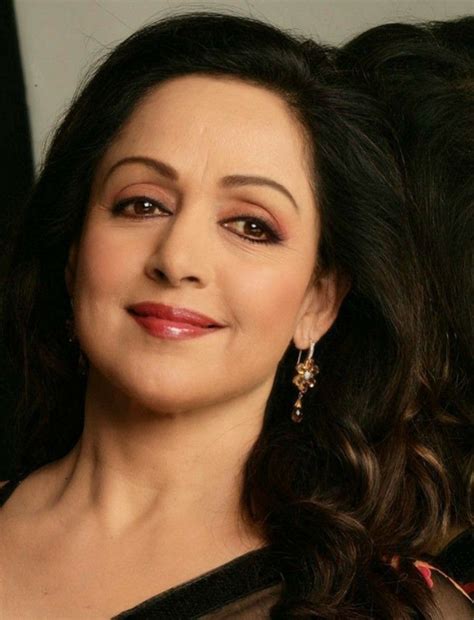 A Close Up Of A Woman With Long Dark Hair Wearing Earrings And A Sheer Top