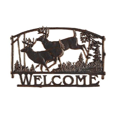 A Metal Sign That Says Welcome With Two Deer