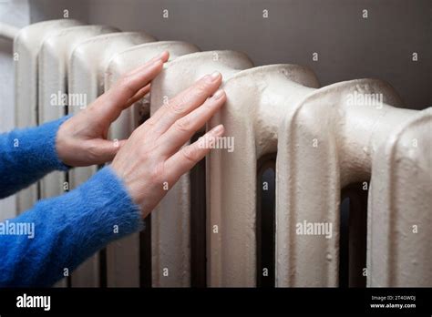 Caucasian Female Holds Her Hands On Hot Water Radiator Home Heating Concept Space For Text