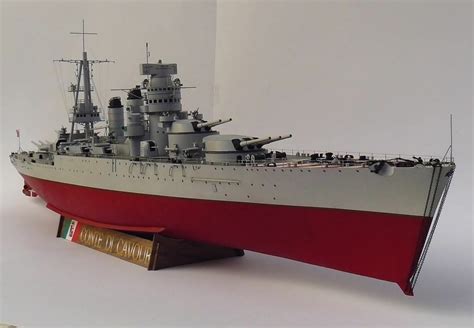 A Model Ship Is Shown On A White Surface With A Red Stripe Around The