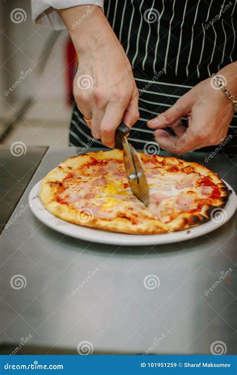 Chef Cutting Pizza With The Round Pizza Cutter Or Knife Stock Image