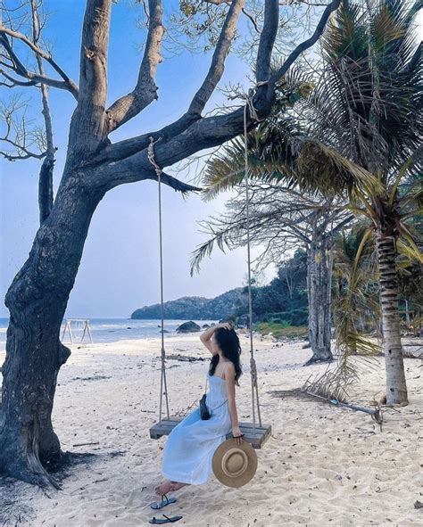 A Woman Sitting On A Swing At The Beach