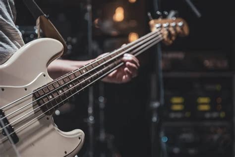 Close Up Of A Bass Guitar In The Hands Of A Musician In The Process Of