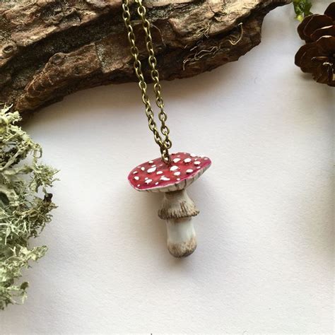 A Necklace With A Red Mushroom On It