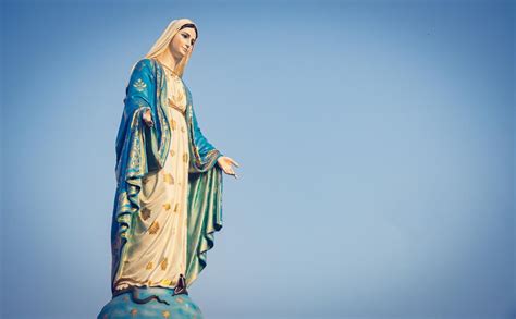 Premium Photo | Low angle view of virgin mary statue against blue sky