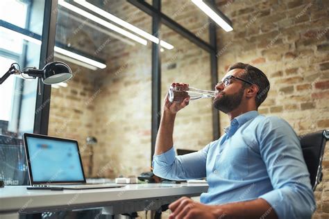 Premium Photo So Thirsty Side View Of Young Bearded Businessman In