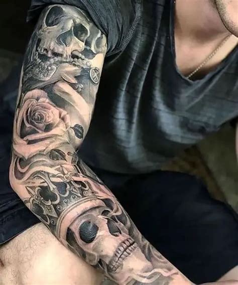 A Man With A Skull And Roses Tattoo On His Arm Is Looking At The Camera