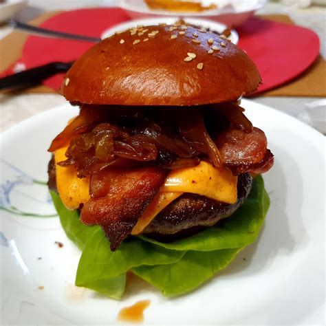 Homemade Burger With Bacon Lettuce And Tomato Topped With Caramelized