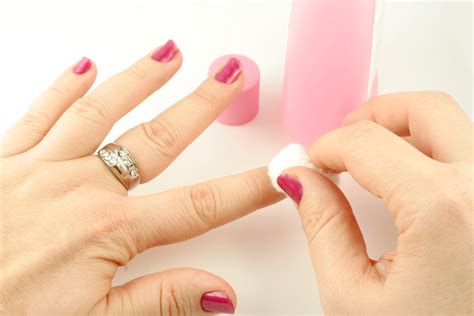 woman holds cotton ball with nail polish remover