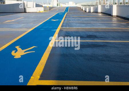 Yellow pedestrian walkway sign painted a road in a car park, UK Stock ...