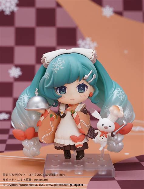 An Anime Figurine Is Posed On A Checkerboard Floor With Snowflakes