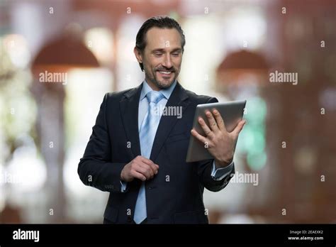 Smiling Mature Businessman Is Looking At Tablet Screen Stock Photo Alamy