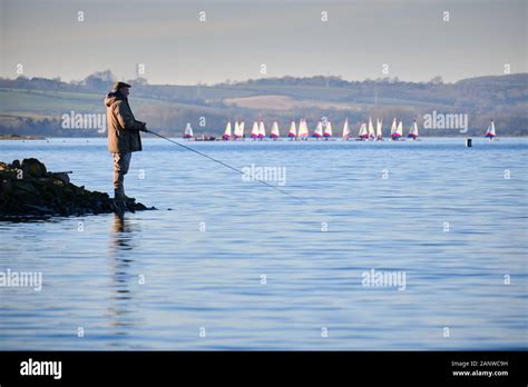 Male Angler Fisherman Sport Fishing On The Shore Of Rutland Water An