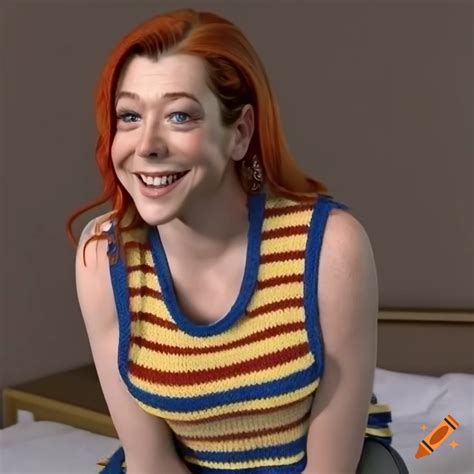 Alyson Hannigan Sitting On A Bed Wearing A Striped Sweater Vest And