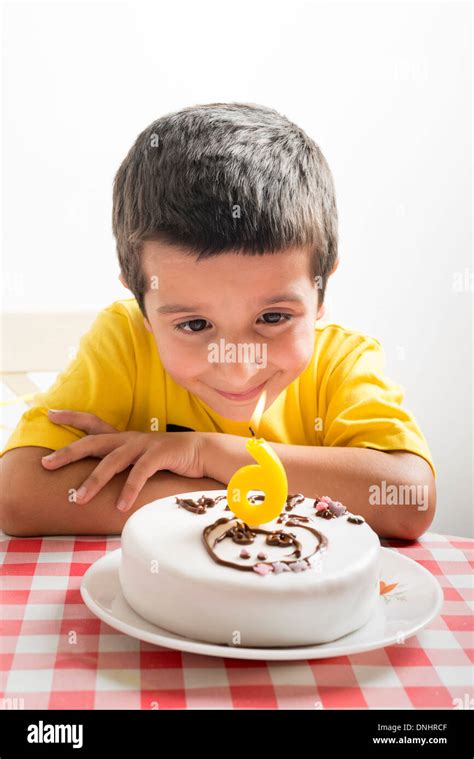 Six year old boy looks at birthday cake Stock Photo - Alamy