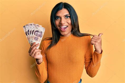 Joven transexual latina transgénero sosteniendo billetes de 500 pesos