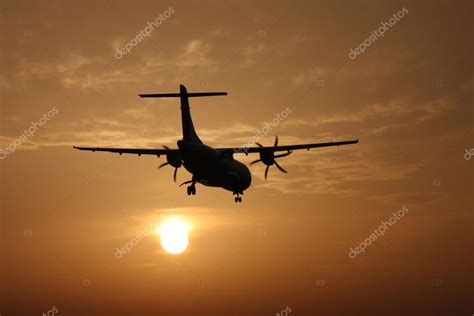 Airplane landing at sunset — Stock Photo © Senohrabek #41980843