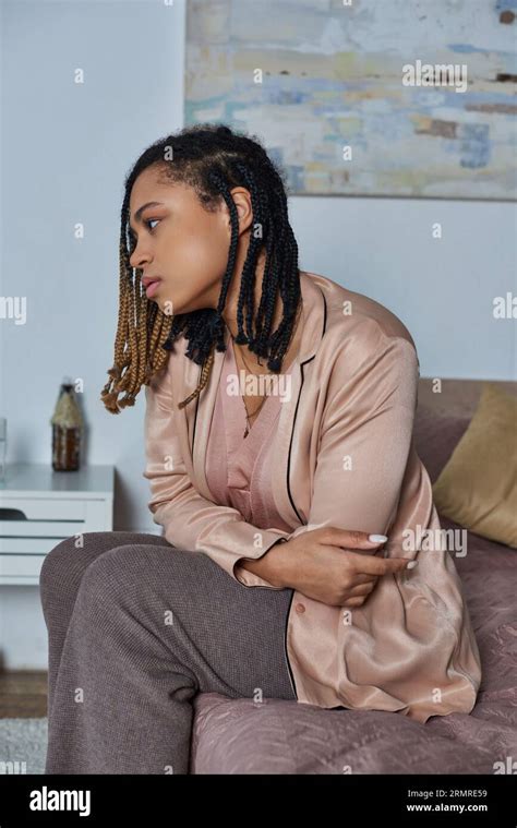 African American Woman Sitting On Bed Feeling Unwell Looking At