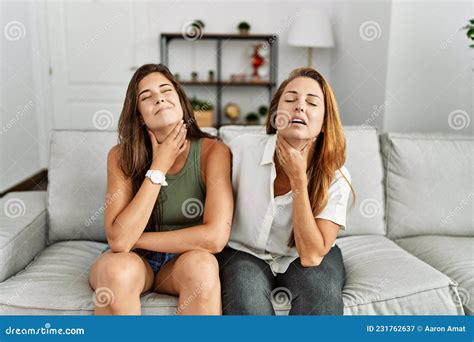 Mother And Daughter Together Sitting On The Sofa At Home Touching