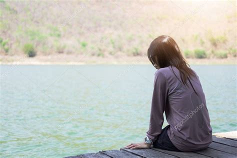 mujer joven sentada sola en balsa de madera frente a sí misma son fondo