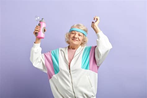 Mujer Mayor En Ropa De Deportes Con La Botella De Agua Que Sonr E Y Que