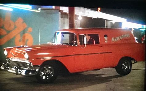 an old red truck parked in front of a building