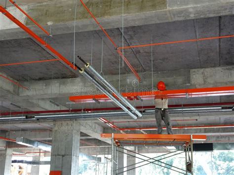 Construction Workers Installing Electrical Cable Tray And Doing Wiring