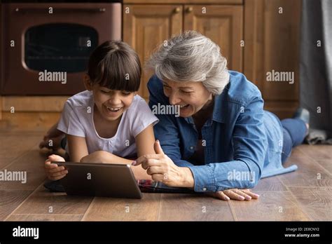 Close Up Overjoyed Mature Grandmother With Granddaughter Using Tablet Stock Photo Alamy
