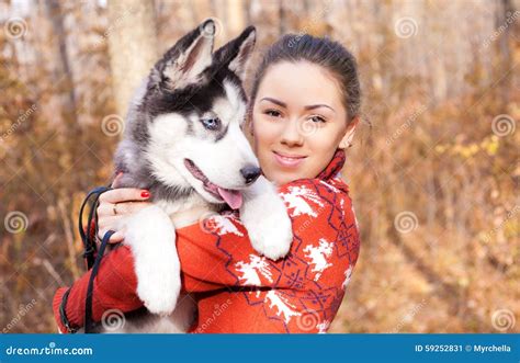 Beautiful Young Woman Hugging Huskies Puppy For A Walk In The Park