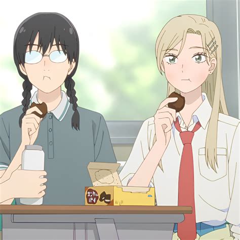 Two People Sitting At A Table Eating Donuts