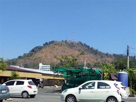 Several Cars Parked In A Parking Lot With A Mountain In The Background