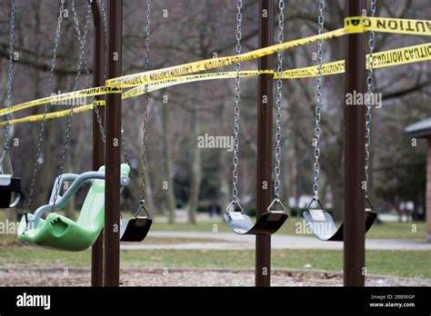 Empty swing set with caution tape to close off playground to children ...