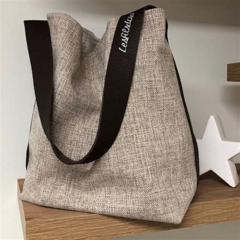 Sac seau en lin gris chiné anse cuir fauve surpiquée sac porté